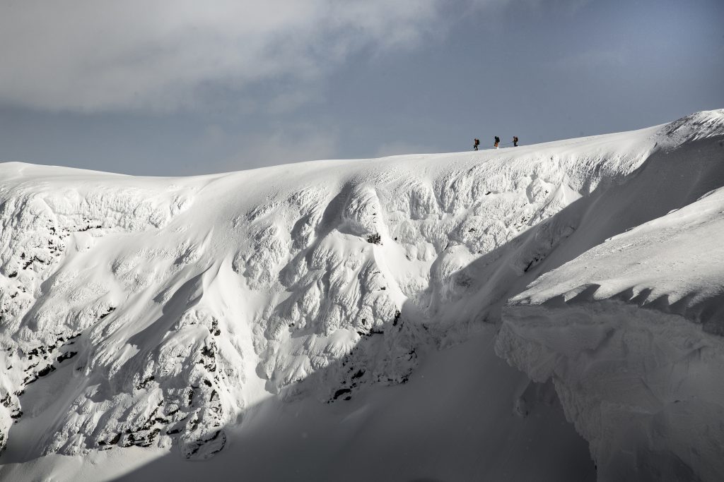 Skiiers on top of a mountain ridge