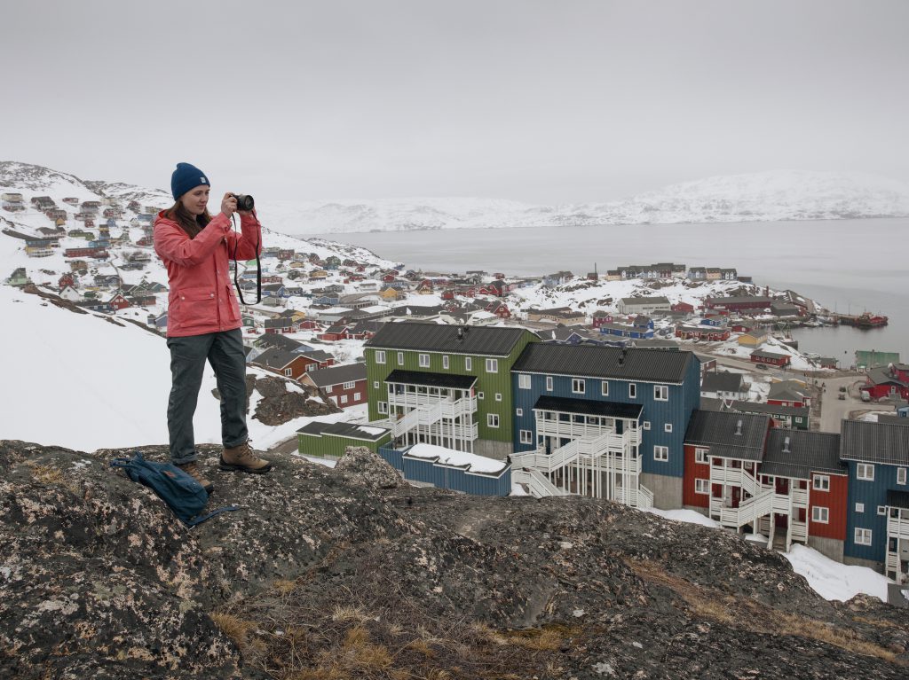 Karina standing infront of a Greenland village.