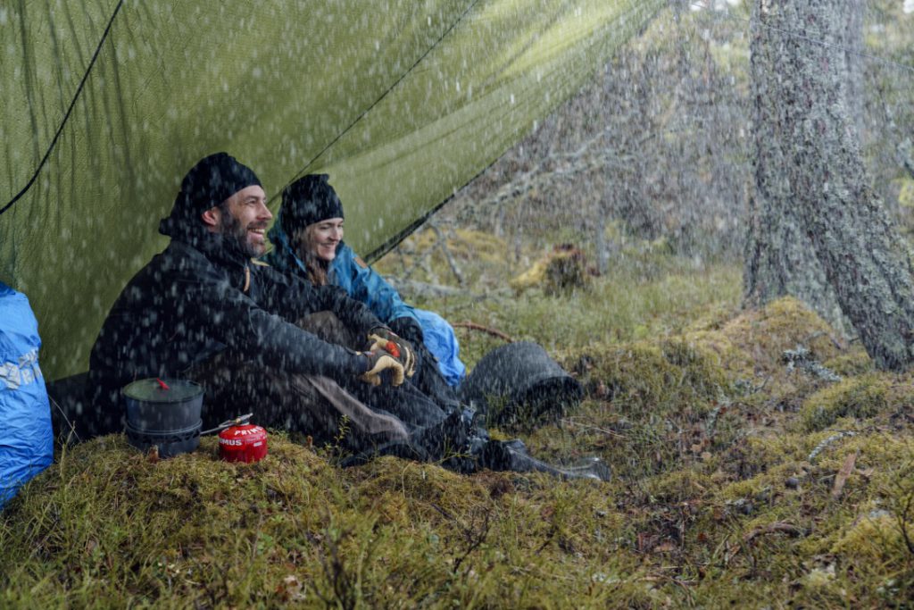 Happy hikers camping in the rain