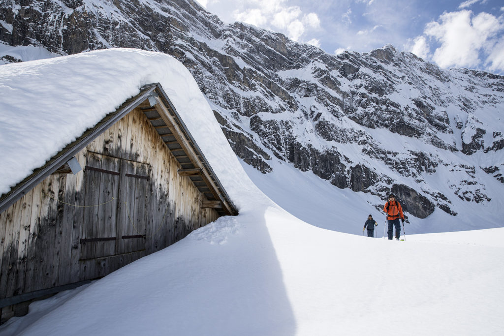Skiing past a snow covered hut